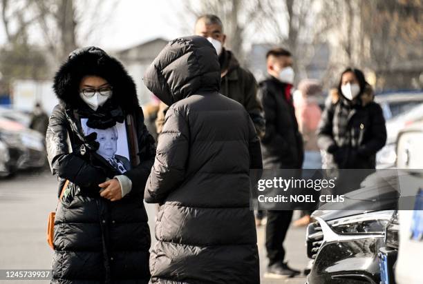 Woman holds a picture frame of a loved one at a crematorium in Beijing on December 20, 2022. - Workers at Beijing crematoriums said on December 16...