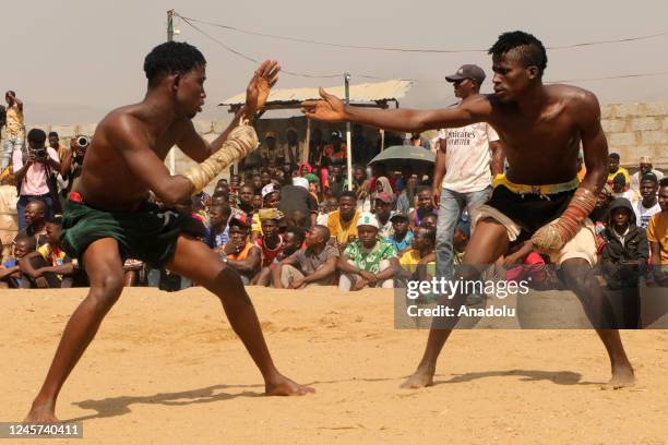 Crowd looks on as two Dambe boxers fight during the Dambe Warriors Tournament held in Abuja, Nigeria on December 11, 2022. Dambe, a brutal style of...