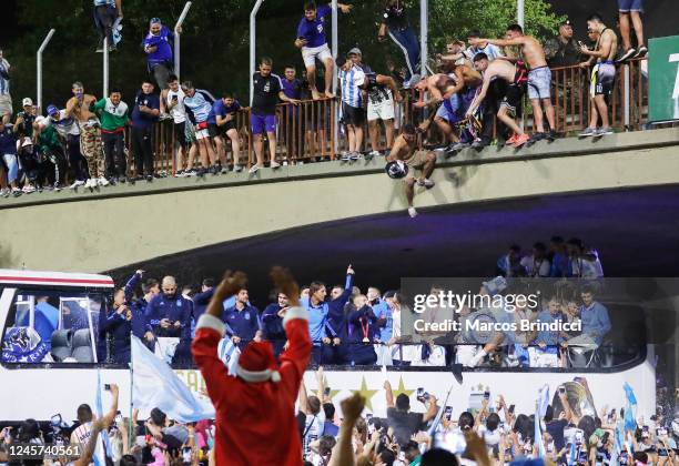 Fan tries to jump onto the bus carrying Argentina men's national football team as they arrive to the teams headquarters after winning the FIFA World...