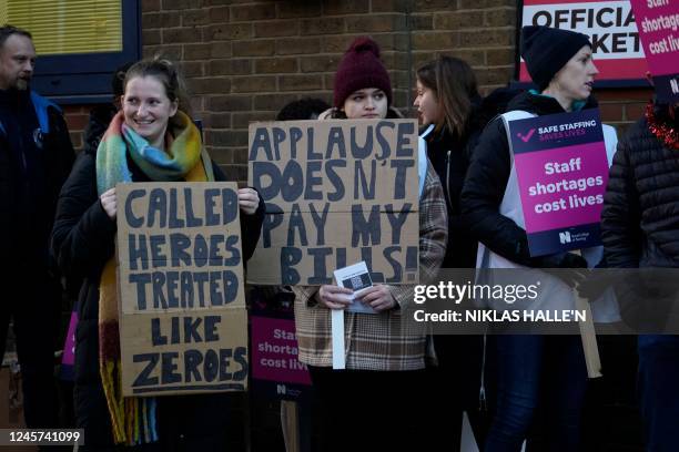 Healthcare workers hold placards at a picket line outside Guy's Hospital in London on December 20, 2022. - UK nurses staged a second unprecedented...