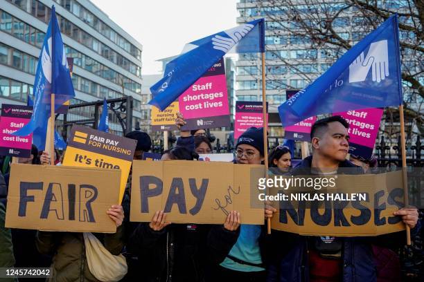 Healthcare workers hold placards at a picket line outside St Thomas' Hospital in London on December 20, 2022. - UK nurses staged a second...