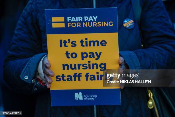 Healthcare workers holds a placard at a picket line outside St Thomas' Hospital in London on December 20, 2022. - UK nurses staged a second...