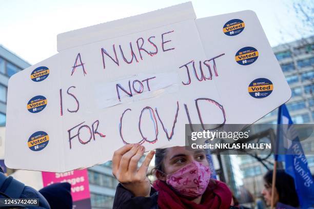 Healthcare workers holds a placard at a picket line outside St Thomas' Hospital in London on December 20, 2022. - UK nurses staged a second...