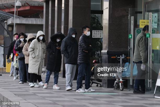 People queue to buy antigen test kits at a pharmacy amid the Covid-19 pandemic in Xian, in China's northern Shaanxi province on December 20, 2022. -...