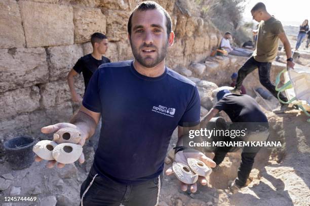 Ziv Firer of the Israel Antiquities Authority shows ancient ceramic clay lamps found during excavations outside the Tomb of Salome in the Lachish...