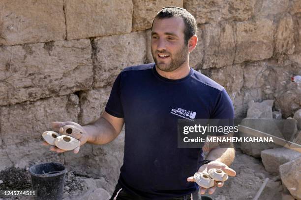 Ziv Firer of the Israel Antiquities Authority shows ancient ceramic clay lamps found during excavations outside the Tomb of Salome in the Lachish...