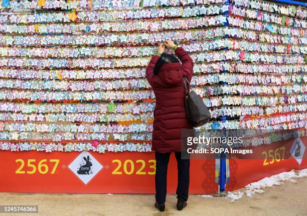 Visitor attaches a New Year's wish note to the 2023 New Year's Wish Tower at Jogyesa Temple, one of the Buddhist temples in Seoul.