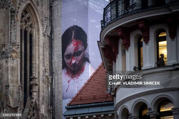 Banner installation by Austrian-Irish visual artist Gottfried Helnwein, depicting a severely injured girl with the inscription "My Sister", hangs on...