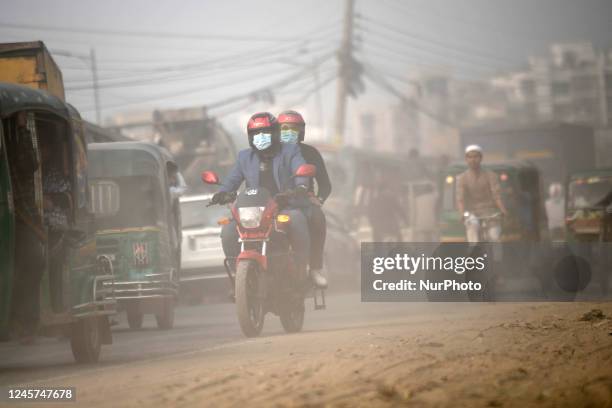 People make their move in a dusty road in Dhaka, Bangladesh on December 20, 2022.