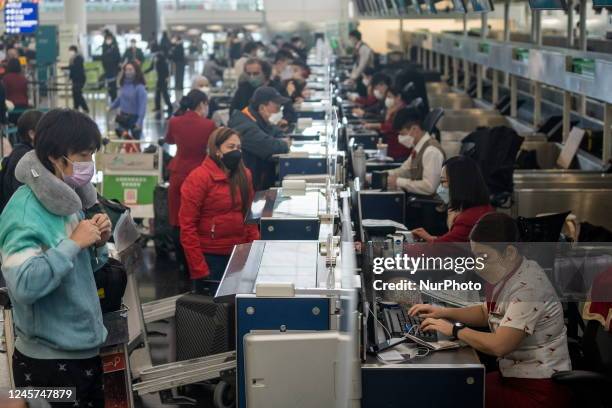 Travelers Checking in at a Cathay Pacific Check In Counter inside Terminal 1 at the Hong Kong International Airport on December 20, 2022 in Hong...