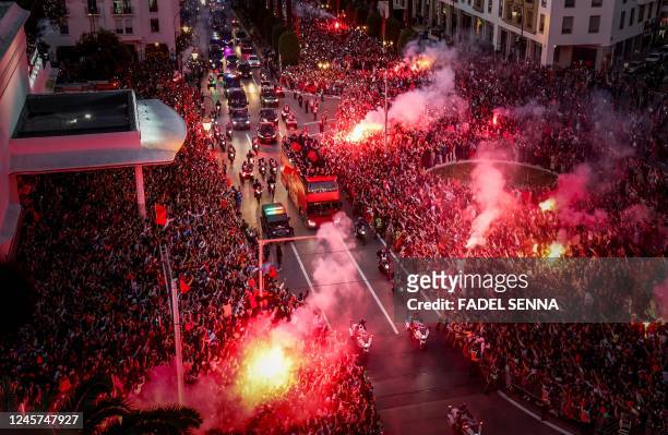 Supporters light flares and cheer as Morocco's national football team arrives to the center of the capital Rabat, on December 20 after the Qatar 2022...