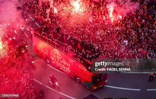 Supporters light flares and cheer as Morocco's national football team arrives to the center of the capital Rabat, on December 20 after the Qatar 2022...