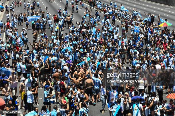 Fans of Argentina celebrate in General Paz avenue as they wait for the victory parade of the Argentina men's national football team after winning the...