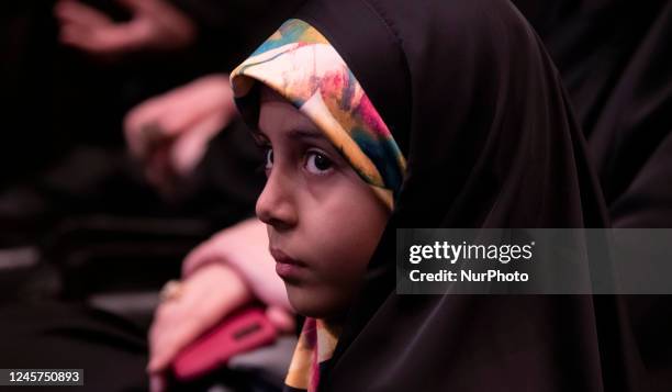 Veiled Iranian girl looks on while attending a ceremony for commemorating death anniversary of an IRGC's Quds force commander in Tehran, December 20,...