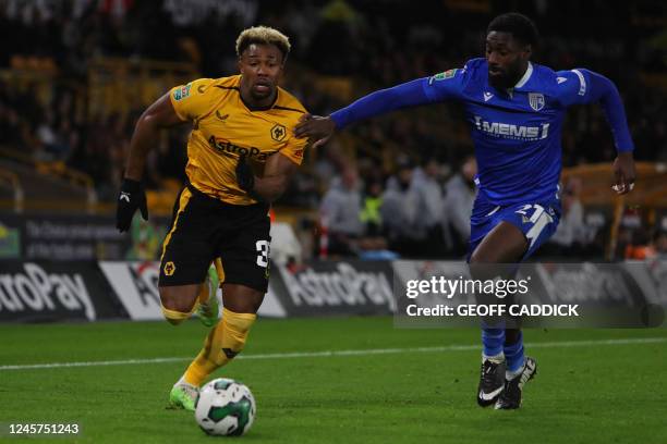 Wolverhampton Wanderers' Spanish midfielder Adama Traore fights for the ball with Gillingham's English midfielder Hakeeb Adelakun during the English...