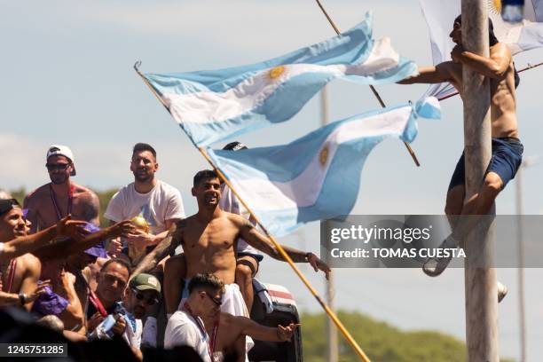 Fan of Argentina clinging to a pole cheers as the team parades on board a bus after winning the Qatar 2022 World Cup tournament, in Buenos Aires...