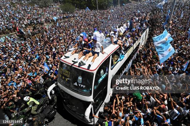 Fans of Argentina cheer as the team parades on board a bus after winning the Qatar 2022 World Cup tournament in Buenos Aires, Argentina on December...