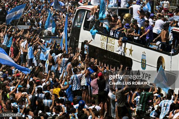 Fans of Argentina cheer as the team parades on board a bus after winning the Qatar 2022 World Cup tournament in Buenos Aires, Argentina on December...