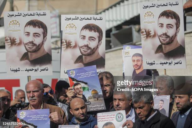 Palestinians hold posters of Palestinian prisoner Nasser Abu Hamid during a protest in front of the International Committee of the Red Cross office...