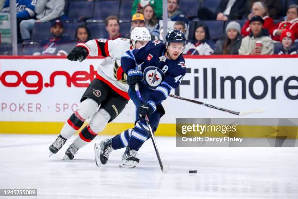 Josh Morrissey of the Winnipeg Jets carries the puck up the ice as Drake Batherson of the Ottawa Senators gives chase during first period action at...