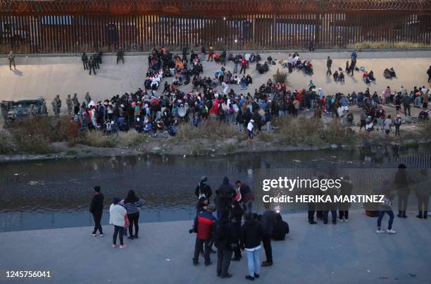 Migrants wait next to the Rio Grande as Texas National Guard soldiers prevent them from turning themselves to Border Patrol agents as seen from...