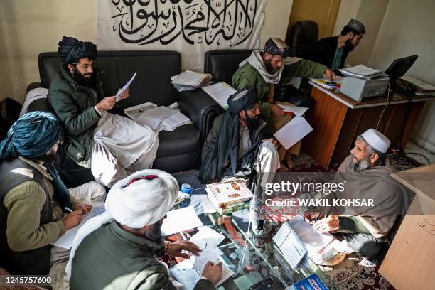 In this photo taken on November 28 judges from the civil court check documents from the case of a petitioner at the Ghazni Court of Appeal in Ghazni,...