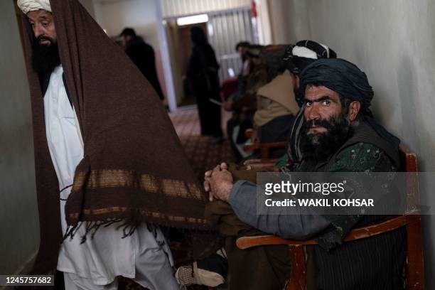 In this photo taken on November 27 Afghan petitioners sit in a corridor of the civil court office at the Ghazni Court of Appeal in Ghazni, eastern...