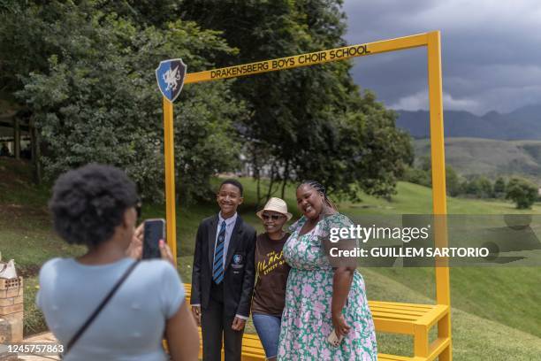 Student from the Drakensberg Boys Choir School poses for a picture with family members at a viewpoint at the school near Winterton on December 10,...