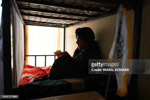 In this photo taken on November 28 a Taliban security guard reads a book in an office at the Ghazni Court of Appeal in Ghazni, eastern Afghanistan. -...