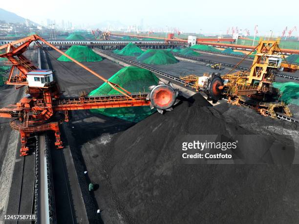 Bucket turbine piles coal recently unloaded by a cargo ship for storage at a coal yard in Lianyungang Port, East China's Jiangsu province, Dec. 21,...