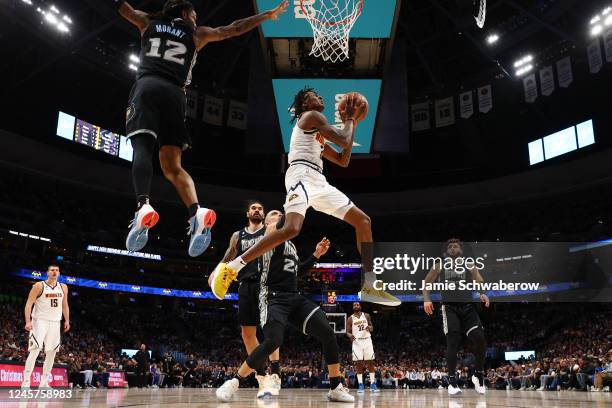 Bones Hyland of the Denver Nuggets drives against Ja Morant of the Memphis Grizzlies in the first half at Ball Arena on December 20, 2022 in Denver,...