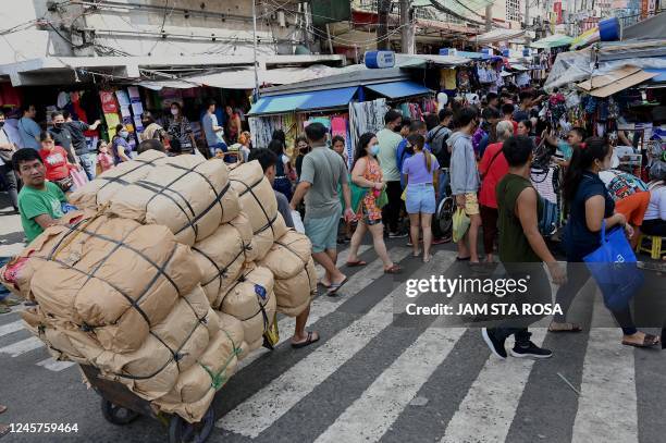 People shop along Divisoria in Manila on December 21 ahead of Christmas day.