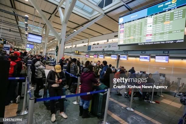 Passengers wait in a check-in line at Vancouver International Airport in Richmond, British Columbia, Canada, on Dec. 20, 2022. Thousands of travelers...