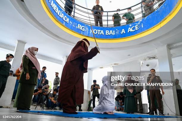 Woman is caned by a sharia policeman as a punishment for being caught in close proximity with a man in Banda Aceh on December 21, 2022.