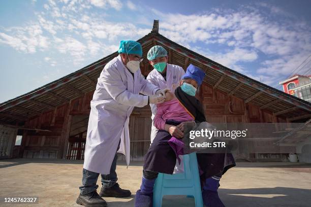 An elderly woman receives a Covid-19 vaccine in Danzhai, in China's southwestern Guizhou province province on December 21, 2022. - China OUT / China...