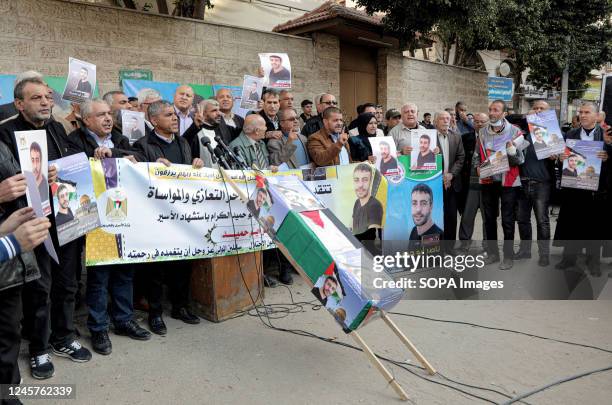 Protesters hold a banner and posters with pictures of the deceased Palestinian prisoner Nasser Abu Hamed during a demonstration in front of the...