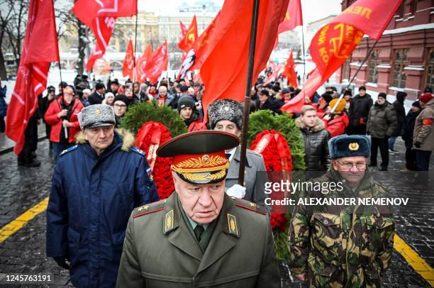 Russian Communist party supporters march to lay flowers to the tomb of late Soviet leader Joseph Stalin during a memorial ceremony to mark the 143-rd...