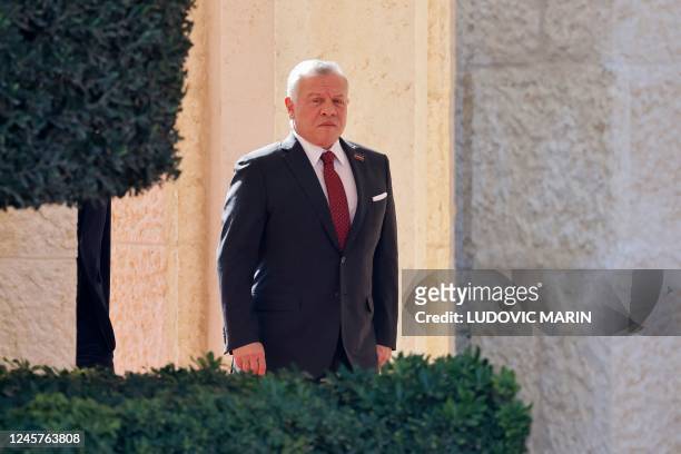 King Abdullah II of Jordan waits for France's President during the offical welcome ceremony at the royal Al-Husseiniya Palace in Amman on December 21...