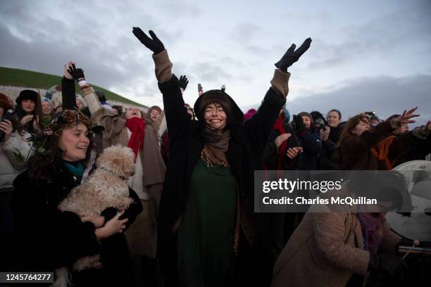 Group celebrates the sun rise as people gather to witness the winter solstice on December 21, 2022 in Newgrange, Ireland. Crowds are gathering at...