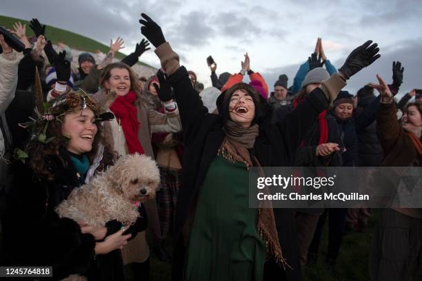 Group celebrates the sun rise as people gather to witness the winter solstice on December 21, 2022 in Newgrange, Ireland. Crowds are gathering at...