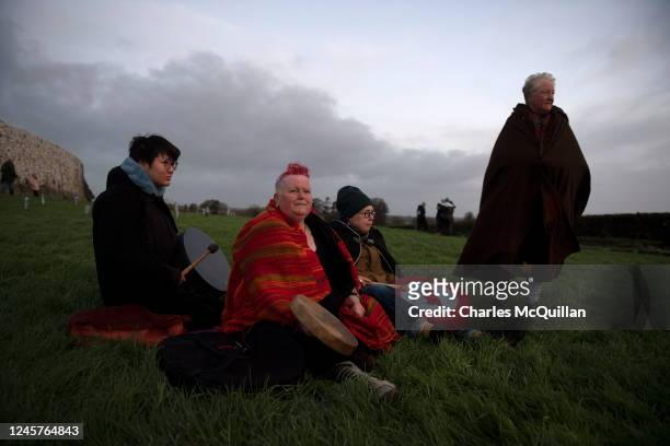 Group of friends watch the sun rise as people gather to witness the winter solstice on December 21, 2022 in Newgrange, Ireland. Crowds are gathering...
