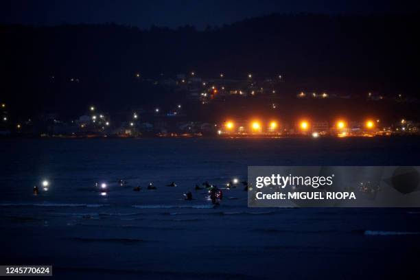 The head torches of "Mariscadoras" sparkle in the darkness as they collect clams and cockles in the Noia estuary, northwestern Spain, early on...