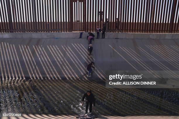 Migrants illegally cross into the United States from Mexico via a hole cut in the border fence in El Paso, Texas, US on December 21, 2022. - The...