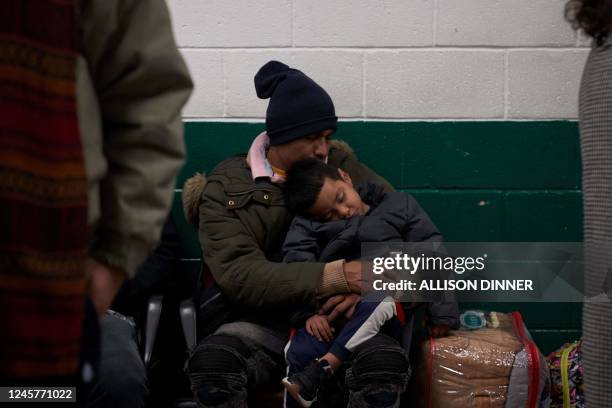 Migrant sleeps with his child while waiting in the local bus station in El Paso, Texas, on December 21, 2022. - The southern border of the United...