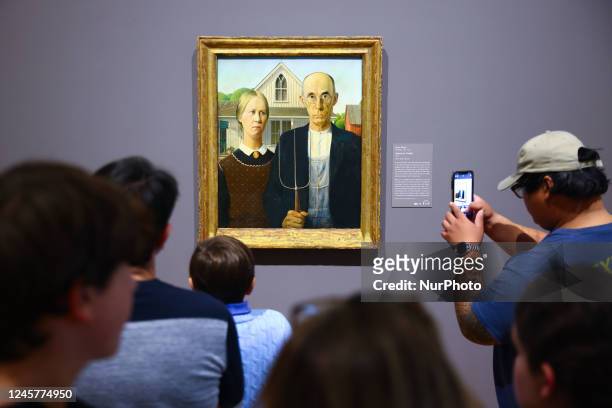 Visitors contemplate 'American Gothic' painting by Grant Wood at Art Institute of Chicago in Chicago, Illinois, United States, on October 17, 2022.