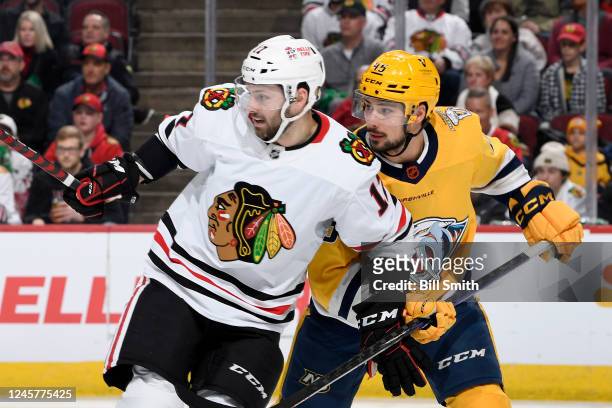 Jason Dickinson of the Chicago Blackhawks and Alexandre Carrier of the Nashville Predators watch for the puck in the first period at United Center on...