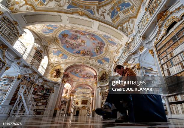 Visitor is seen in the library of the Benedictine Abbey in Admont, Austria on December 6, 2022. - The Admont abbey library nestled amid the mountains...