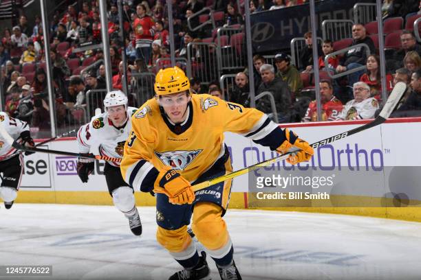 Jeremy Lauzon of the Nashville Predators watches for the puck as Sam Lafferty of the Chicago Blackhawks follows behind, in the third period at United...