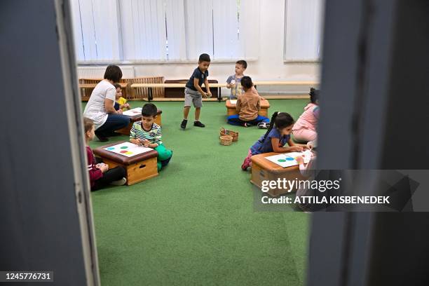 Picture taken on December 14, 2022 shows child development specialist Valeria Toth practicing magic tricks with children at the Viragkoszoru...