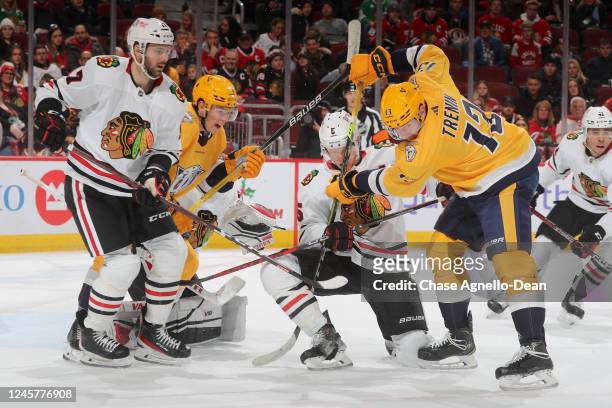 Connor Murphy of the Chicago Blackhawks and Yakov Trenin of the Nashville Predators get physical in front of Jason Dickinson of the Chicago...